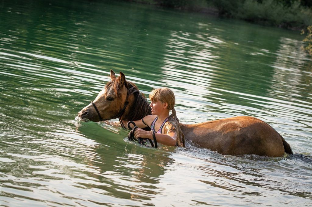 Girl swimming with her horse